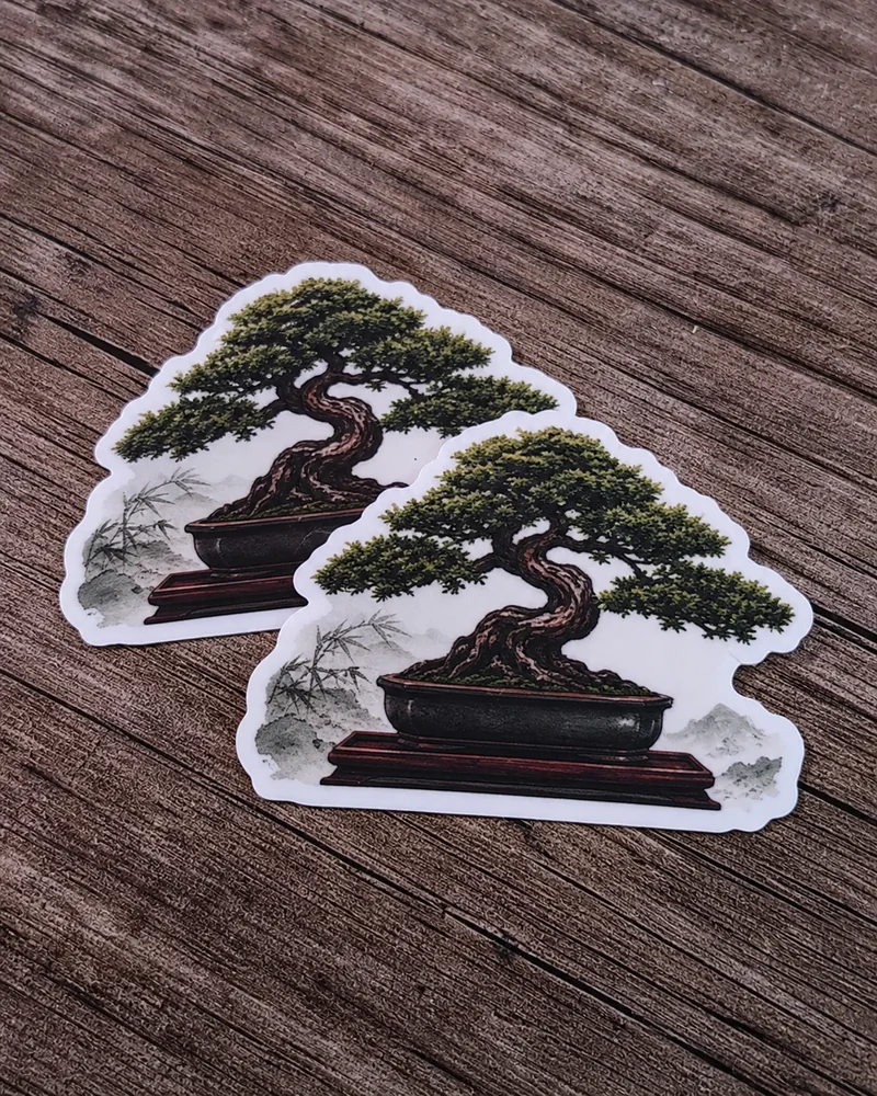 Twee contourgesneden bonsaistickers op een houten ondergrond